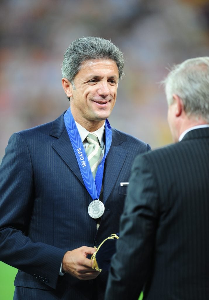 Gheorge  Popescu (L) receives a cap from